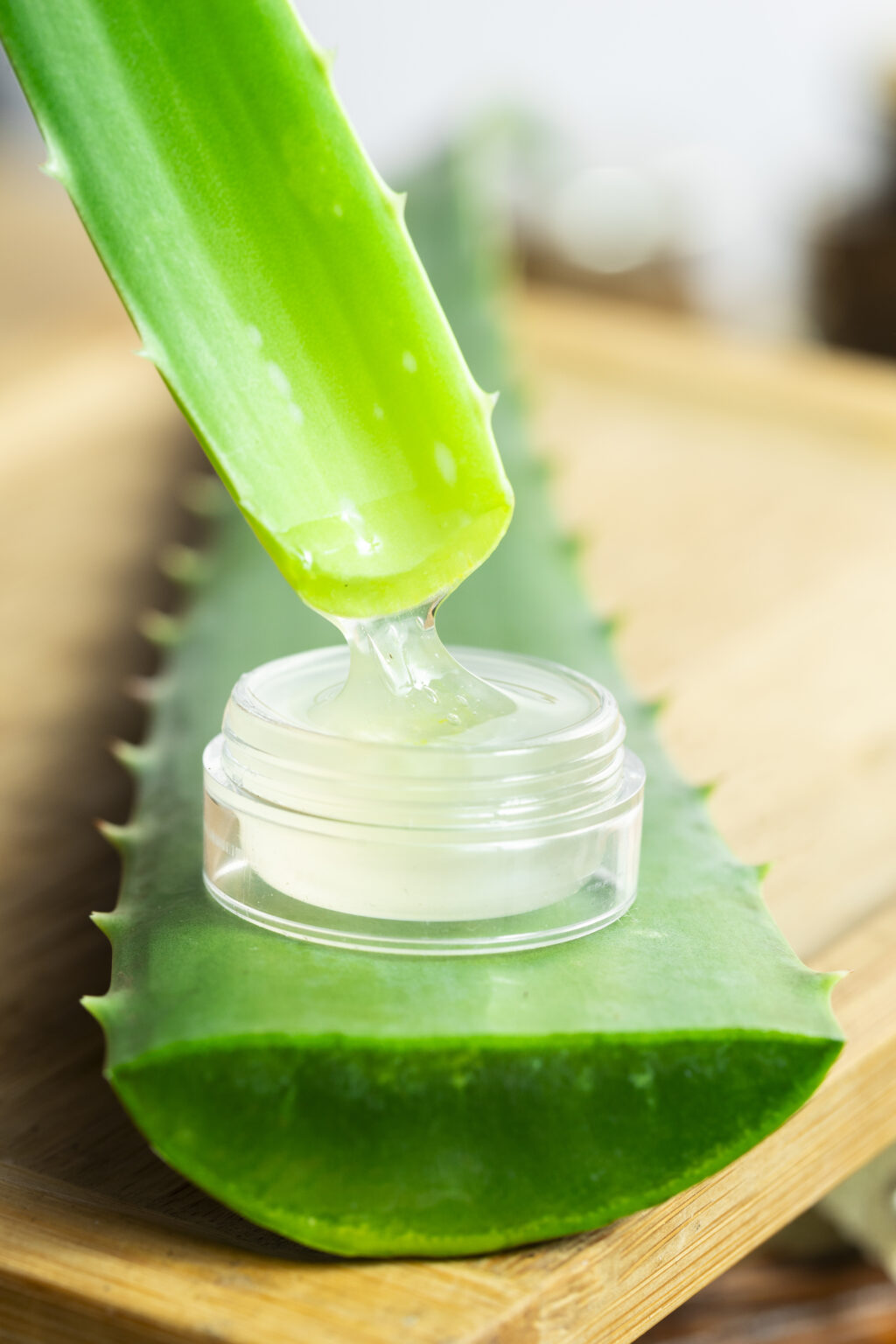 You can see two aloe leaves and a glass container containing aloe gel