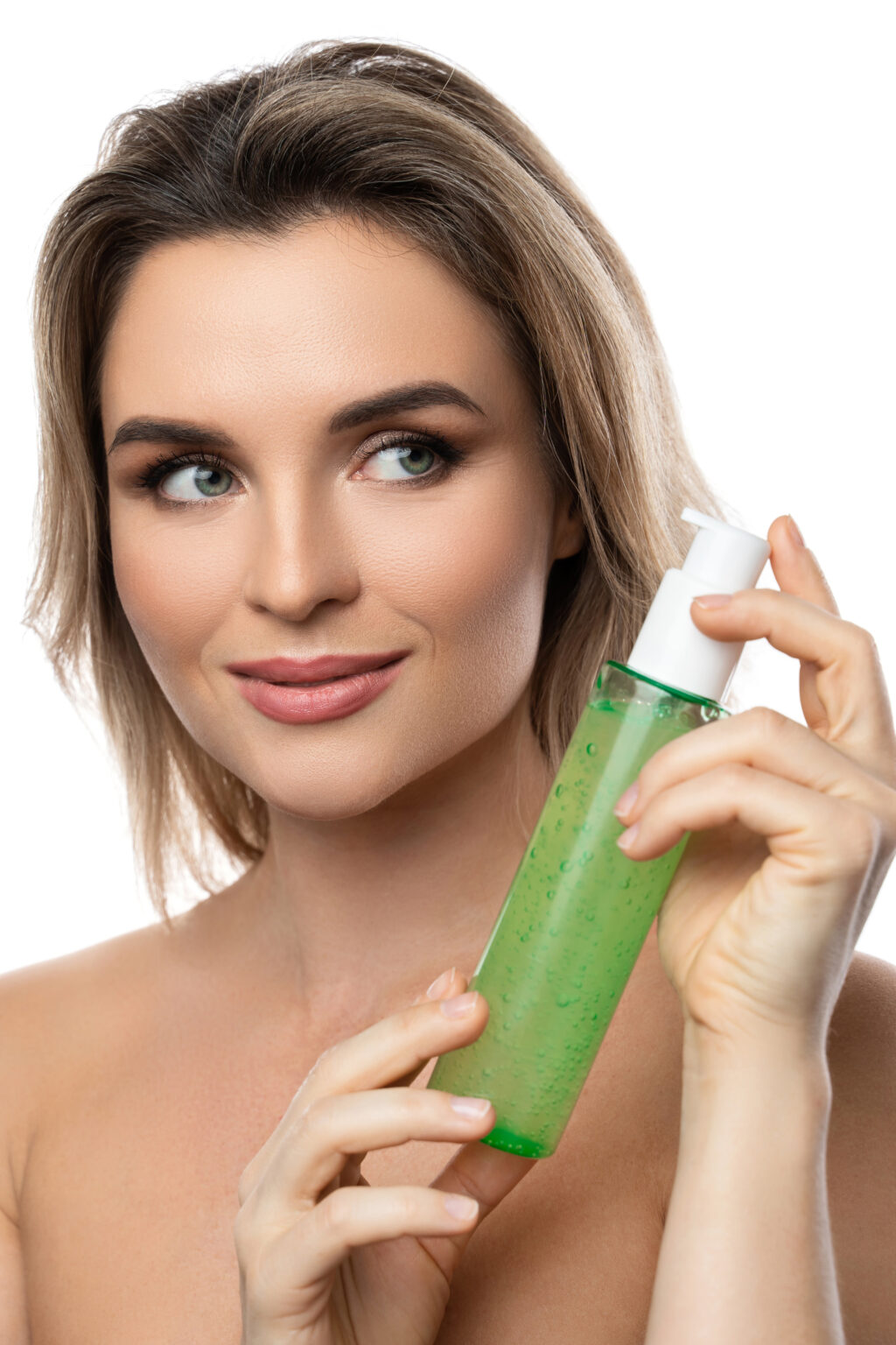 Young woman with a smooth skin holding a bottle of green cleansing gel on white background